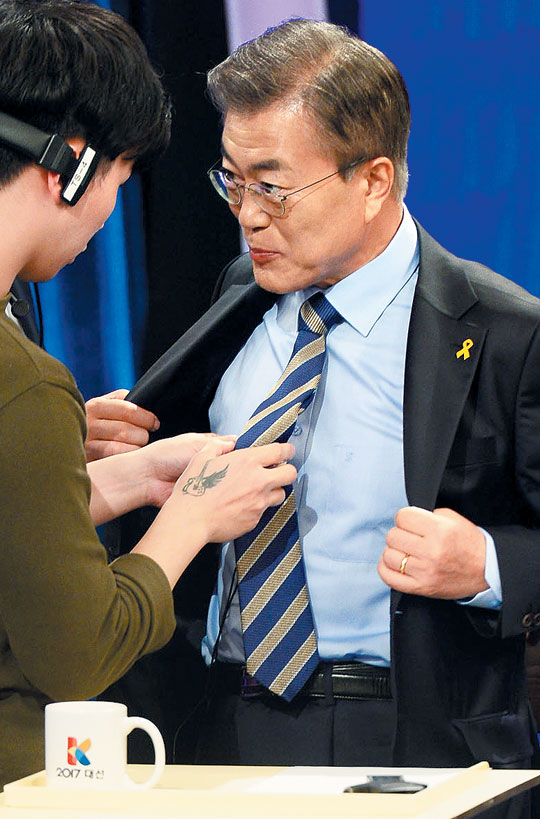 문재인 더불어민주당 대선 후보가 19일 밤 서울 KBS에서 TV 토론이 시작되기 전 마이크가 잘 달렸는지 점검하고 있다.
