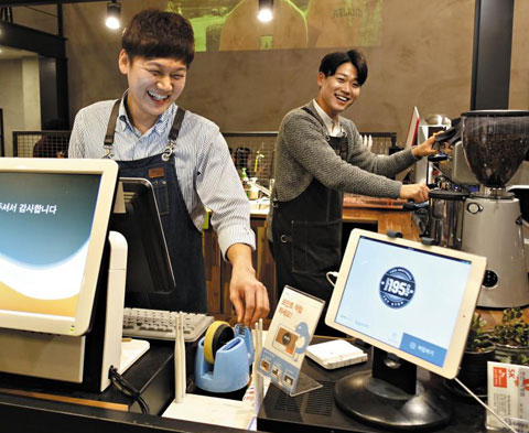 쿠폰·포인트 적립 서비스업체 스포카와 제휴를 맺은 매장에서 종업원이 고객의 전화번호를 입력해 고객에게 포인트를 적립해주고 있다.