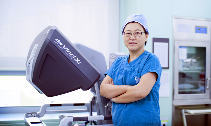 서울성모병원 김미란 산부인과 교수가 로봇 수술 장비 ‘다빈치’ 옆에 서 있다. 김 교수는 한국인 중 처음이자 세계에서 네 번째로 로봇 자궁근종 적출 수술 500회 대기록을 달성했다.