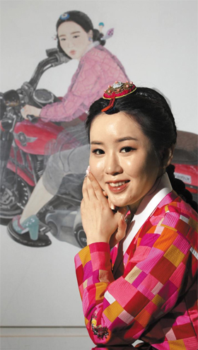 포브스가 선정한 ‘아시아에서 영향력 있는 30세 이하 30인’에 이름을 올린 화가 김현정씨는 “대중에게 사랑받는 ‘젊은 동양화’를 그리고 싶다”고 했다. 뒤로 보이는 작품은 한복을 입고 오토바이 타는 여성을 그린 ‘내숭: 취향 저격’