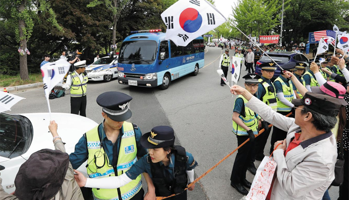 호송차로 이동 - 23일 경기도 의왕시 서울구치소 앞에서 박근혜 전 대통령을 태우고 서울 서초구 서울중앙지법으로 떠나는 호송차량을 향해 박 전 대통령 지지자들이 태극기를 흔들고 있다.