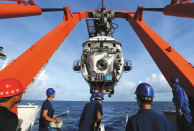 중국의 유인 심해탐사정 자오룽이 25일 마리아나 해구에서 해저 6300미터에 남겨져 있던 채수기를 회수하고 있다. /신화망