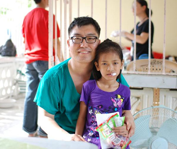 2008년 9월 필리핀의 한 마을에서 현지 소녀에게 치과 치료를 해주고 함께 포즈를 취한 오동찬씨.