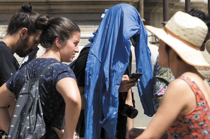 17일(현지 시각) 스페인 남부의 세비야를 찾은 관광객들이 모자를 쓰거나 재킷을 뒤집어쓰고 있다.