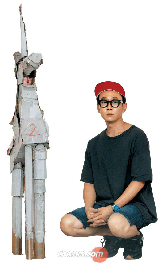 택배 상자로 만든‘유니콘’옆에 앉은 문형태 작가.