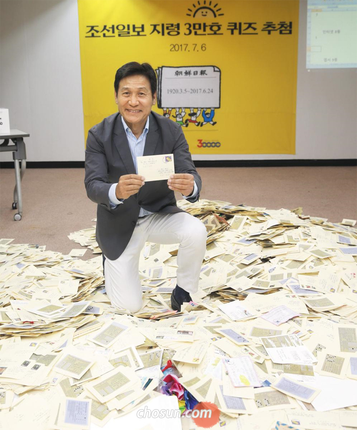 배우 안성기씨가 6일 서울 광화문 조선일보 사옥에서 ‘지령 3만호 퀴즈’에 응모한 11만여 통 엽서 중 1등 당첨 엽서를 들어 보이고 있다.