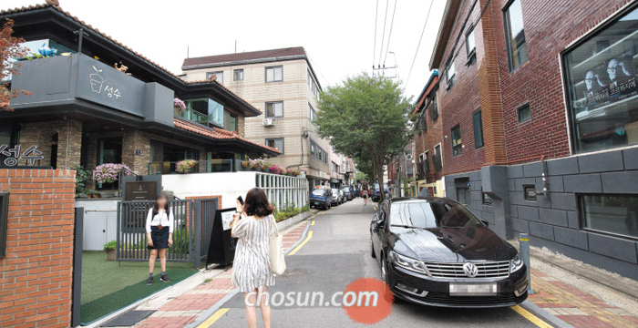 지난 14일 오후 서울 성동구 서울숲길의 한 카페 앞에서 사진을 찍는 여성들. 성동구가 다음 달부터 ‘성수동 카페거리’로 불리는 이곳에 프랜차이즈 업체의 입점을 제한하기로 결정하자 지역 주민들 사이에서도 찬반이 엇갈리고 있다.
