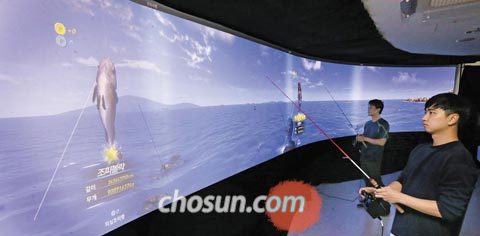 스크린골프를 개발한 골프존뉴딘그룹의 자회사 뉴딘플렉스 개발자들이 18일 사무실에서 개발 중인 스크린낚시를 테스트하고 있다.