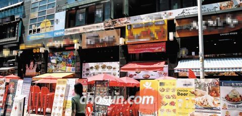 서울 명동의 거리에 음식점들이 내놓은 이동식 대형 메뉴판들이 줄을 지어 서 있다. 