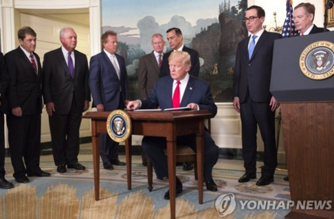 도널드 트럼프 미국 대통령이 중국의 지재권 침해조사 검토를 지시하는 행정명령에 서명하고 있다. /연합뉴스