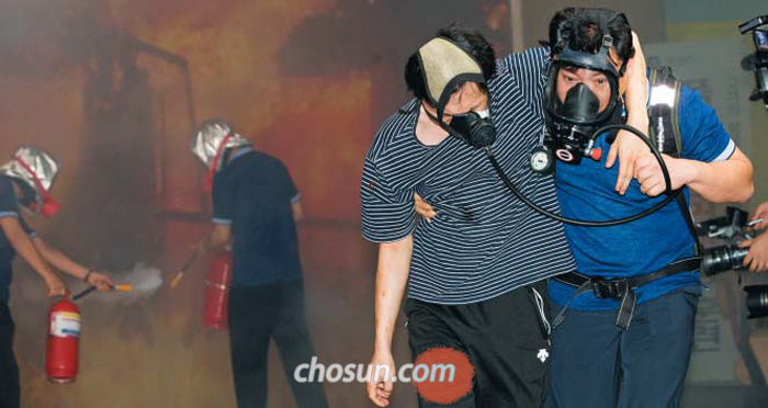 22일 오후 지하철 4호선 사당역에서 역무원(오른쪽)이 시민에게 산소마스크를 씌워 대피시키고 있다. 서울교통공사는 이날 오후 2시부터 20분간 시민 60여 명과 함께 독가스·폭탄 공격 상황에 대비한 훈련을 진행했다.