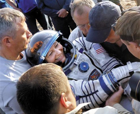 페기 윗슨이 NASA 직원들의 도움을 받아 귀환 캡슐에서 나오고 있다. 