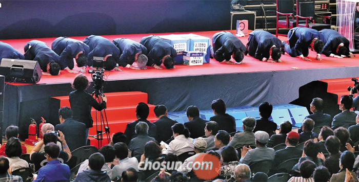 “한 표 부탁드립니다” - 반포주공1단지 재건축에 입찰한 한 건설사 관계자들이 27일 조합 임시총회에서 사업 설명을 한 다음 조합원들에게 절을 하고 있다. 투표 결과, 조합원 2193명 중 과반인 1295명(59%)의 지지를 받은 현대건설이 시공권을 따냈다.