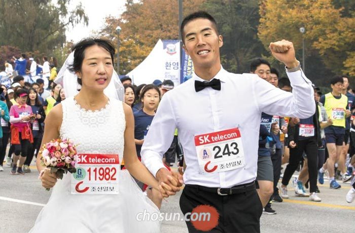 이런 로맨틱한 마라톤 처음이야 - 이들에게 춘천마라톤 현장은 결혼식장이었고, 춘천마라톤 참가자들은 하객이었다. 29일 춘천마라톤이 끝난 뒤 결혼식을 올린 서무영씨와 박지우씨가 턱시도와 웨딩드레스 차림으로 10㎞ 코스를 뛰는 모습. 춘천마라톤 참가자들은 이들을 향해 축하의 환호를 보냈다.