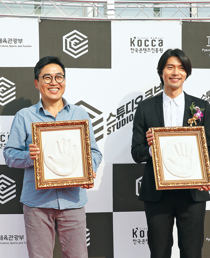스튜디오 큐브 개관식에 참석한 김성훈 영화감독과 배우 현빈이 핸드프린팅을 하고 있다