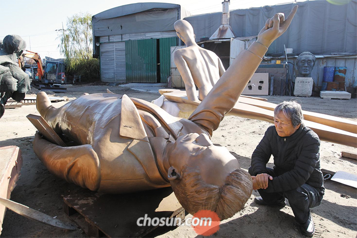 오른손을 든 채 어딘가를 가리키고 있는 박정희 전 대통령 동상을 조각가 김영원이 침울한 표정으로 바라보고 있다. 경기도 한 주조공장 맨땅에 누워 있는 이 동상은 지난 13일 박정희 탄생 100주년을 맞아 서울 상암동 박정희대통령기념도서관에 건립될 예정이었다. 