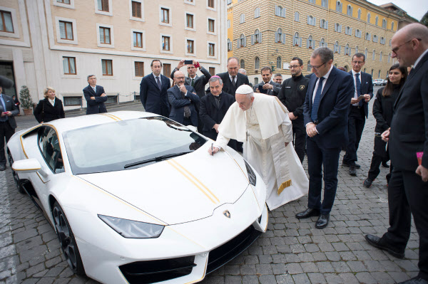15일(현지 시각) 바티칸에서 프란치스코 교황이 선물 받은 람보르기니 우라칸(huracan)에 축복을 내린 뒤 보닛에 서명하는 모습./AFP=연합뉴스