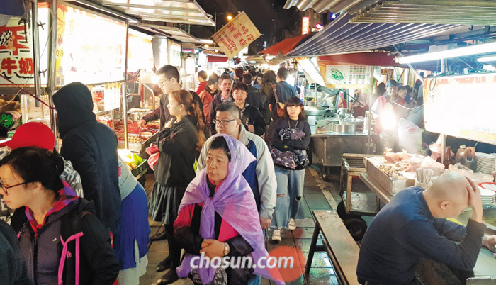 지난 22일 대만 타이베이시에 있는 닝샤(寧夏) 야(夜)시장에서 관광객들이 문어 구이, 우육면, 딤섬 등 다양한 음식을 파는 상점들을 구경하고 있다. 야시장 상인 린딩궈씨는 “올해 들어 특히 베트남·태국 등 동남아 손님이 눈에 띄게 늘고 있다”고 했다.