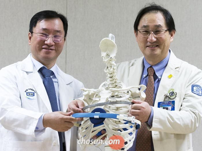 오목가슴 수술 전문 서울성모병원 흉부외과 박형주(오른쪽) 교수와 새가슴 교정 전문 강남세브란스병원 흉부외과 이성수 교수가 흉곽 모형을 놓고 오목가슴 수술 기구와 새가슴 보조기를 대보고 있다.