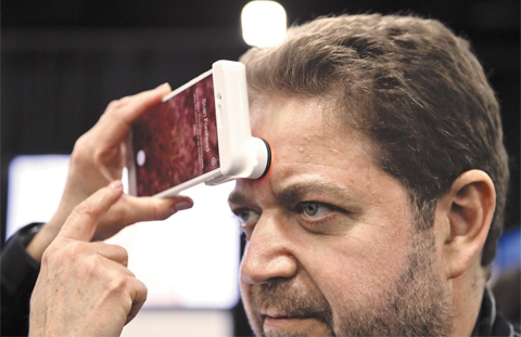 7일(현지 시각) 세계 최대 IT(정보기술) 전시회 ‘CES 2018’ 사전 공개 행사에서 한 참석자가 뉴트로지나의 피부 분석기로 자신의 피부 상태를 체크하고 있다.