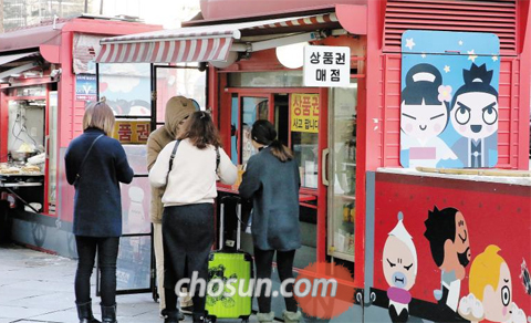 지난 9일 오후 서울 명동의 롯데백화점 앞 상품권 판매 점포에서 중국인 관광객들이 백화점 상품권을 구입하고 있다.