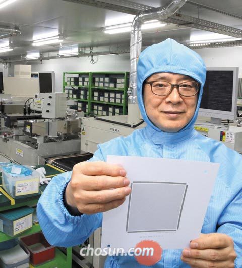 지난 10일 인천 남동구 남동공단에 있는 아모텍 본사 세라믹 칩 제조 라인에서 김병규 회장이 세계 1위인 감전방지소자 회로도를 들어 보이고 있다.