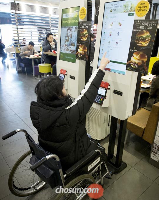 한 패스트푸드점에서 본지 김유정 인턴기자가 휠체어에 앉아 무인 주문기를 사용하고 있다.