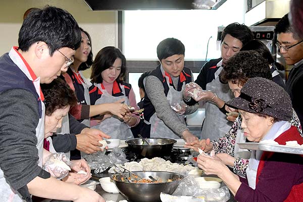 KT IS 임직원이 센터 어르신들과 만두빚기, 밑반찬 만들기를 하고 있다.