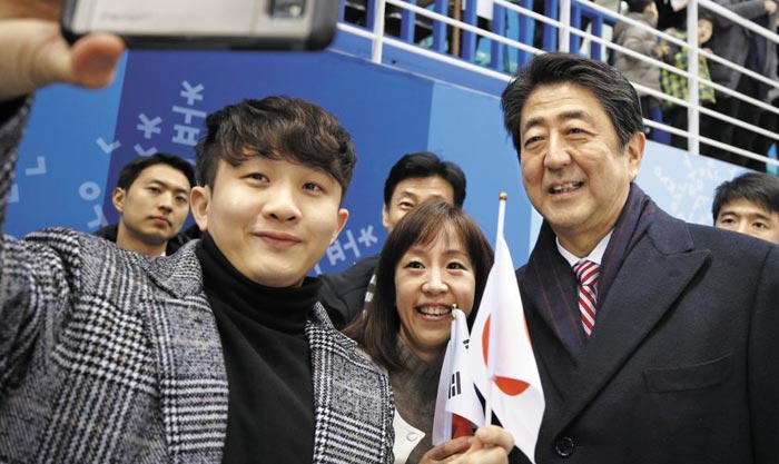 아베 신조(맨 오른쪽) 일본 총리가 10일 평창올림픽 여자 아이스하키 경기가 열린 강원도 강릉 관동하키센터를 찾아 관중들의 사진 촬영 요청에 응하고 있다.
