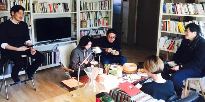 낯선 사람들이 거실을 책방처럼 꾸민 집에 모여 얘기를 나눈다.