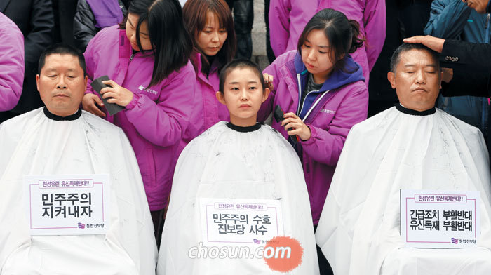 김재연(가운데) 전 의원이 2013년 11월 6일 국회 본청 계단에서 정부의 통합진보당 해산 심판 청구에 항의하며 삭발하고 있다.
