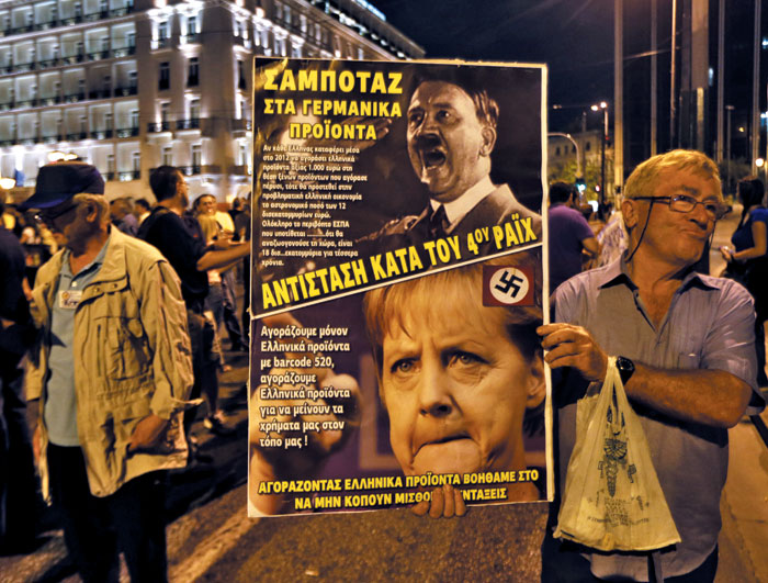 지난 2012년 각종 긴축정책에 반대하는 그리스 국민들이 그리스 아테네 국회의사당 앞에서 메르켈 독일 총리를 히틀러에 비유하며 시위를 벌이고 있다.