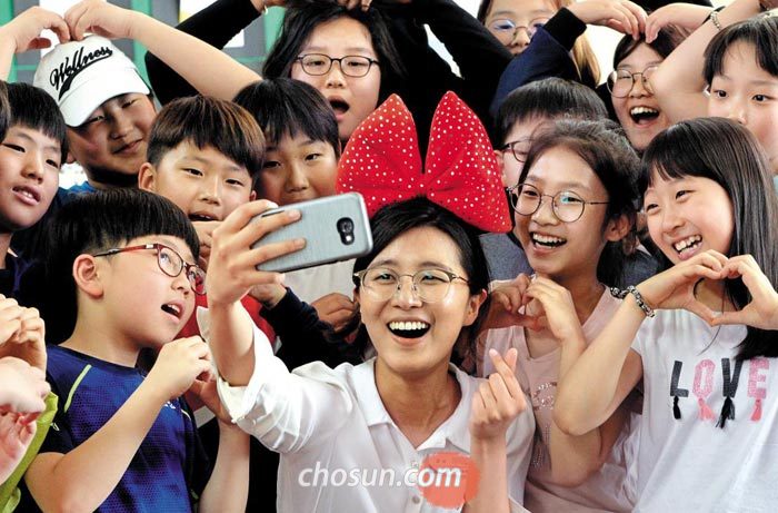 스승의 날을 하루 앞둔 14일 대전 둔산초등학교 5학년 4반 학생들이 손으로 하트 모양을 그리면서 담임선생님과 기념사진을 찍고 있다.