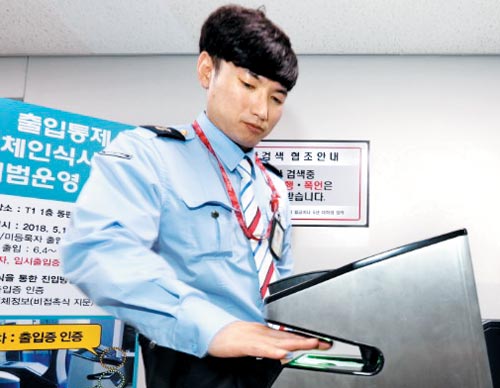 16일 인천공항 1터미널 상주 직원 출입구에 시범 도입된‘비접촉 지문 인식 기기’에 인천공항공사 직원이 손을 집어넣으며 시연하고 있다.