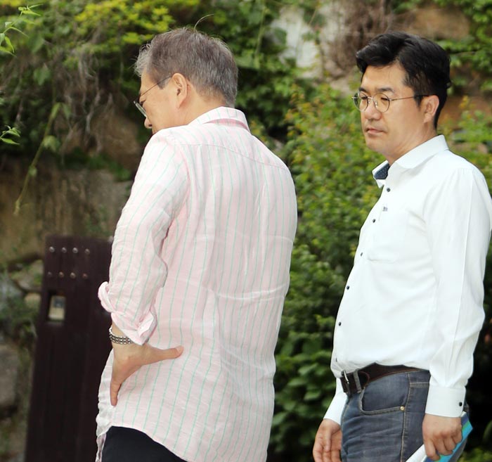 지난해 5월 21일 경남 양산시 사저를 찾은 문재인(왼쪽) 대통령이 송인배 청와대 제1부속비서관이 건넨 전화기를 들고 통화를 하고 있다.