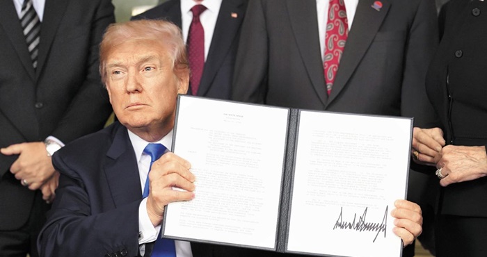 트럼프 대통령이 지난 3월 백악관에서 중국에 대한 무역 제재안에 서명한 뒤 결재판을 들어보이고 있다.