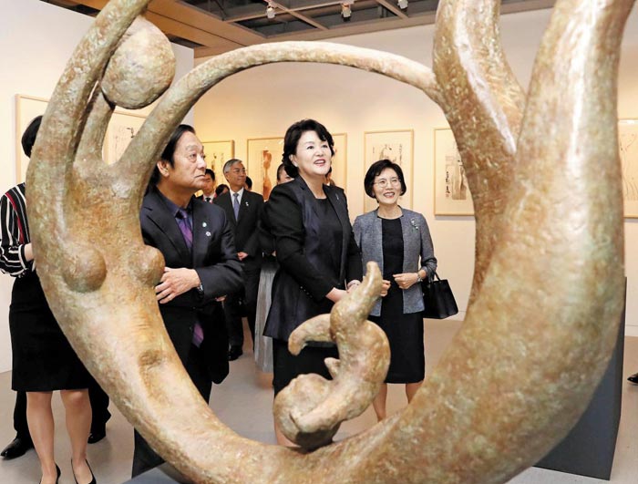 5일 개막식에 온 김정숙 여사가 한메이린의 청동조각상‘엄마와 아들’을 관람하고 있다.