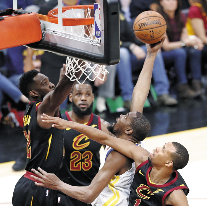 듀랜트, 3명 제치고 슛 - NBA 챔피언결정전 3차전에서 골든스테이트 워리어스 승리를 이끈 영웅은 케빈 듀랜트(흰색 상하의)였다. 듀랜트가 캐벌리어스 수비 숲 사이로 솟아올라 슛을 시도하는 모습. 이날 그는 43점을 쏟아 부으며 팀의 파이널 3연승을 이끌었다.