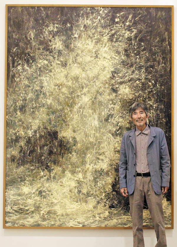 파도가 바위를 치고 올라가다 하얗게 부서지는 풍경을 담은 '치솟음' 앞에 선 화가 강요배.