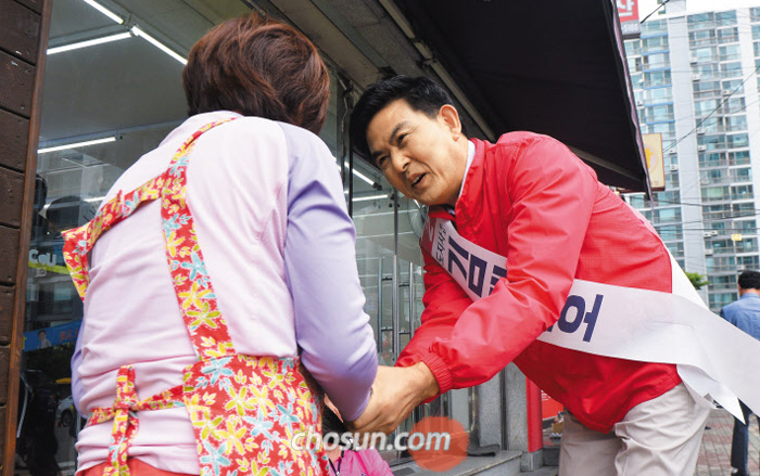 자유한국당 김태호 경남지사 후보가 11일 경남 김해시 어방동에서 도민과 악수하고 있다. 김 후보는 당 지도부에 지원 유세를 요청하지 않고 ‘나 홀로 유세’를 하고 있다.