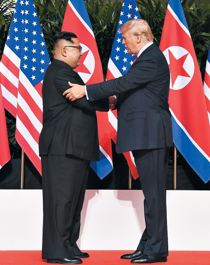 도널드 트럼프 미국 대통령과 김정은 북한 국무위원장이 12일 첫 인사를 나누고 있다.