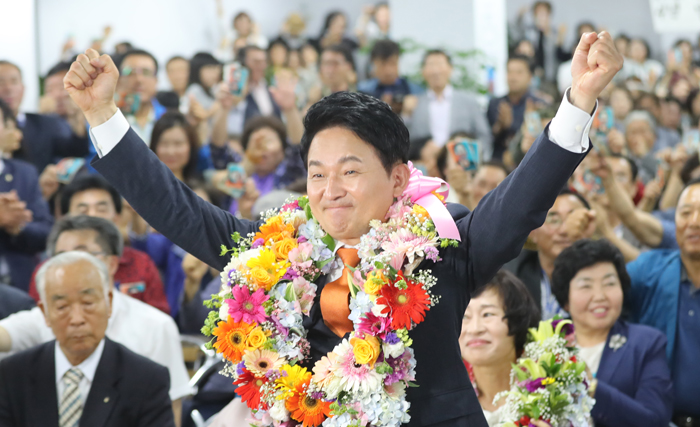 두 손 번쩍 들고 환호 - 무소속 원희룡 제주지사 후보가 13일 당선이 확실시된 후 제주 선거사무실에서 꽃다발을 목에 걸고 손을 들며 환호하고 있다.