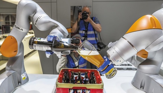 지난 4월 22일(현지 시각) 독일 하노버 메세에서 산업용 로봇 기업 쿠카(KUKA)가 개발한 로봇 팔이 맥주를 잔에 따르고 있다.