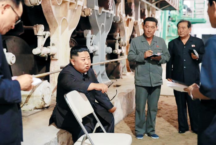 김정은(왼쪽에서 둘째) 북한 국무위원장이 신의주 화학섬유 공장에서 인상을 찌푸린 채 얘기하고 있다.
