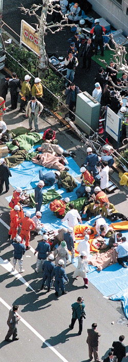 1995년 그때 1995년 3월 20일 도쿄 지하철 쓰키지역 인근에서 구조대원들이 사린 가스를 마신 시민들에게 응급 조치를 하고 있다.
