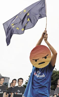 지난 5월 벨기에 브뤼셀에 있는 유럽 의회 앞에서 ‘페이크북(fakebook·가짜)을 고쳐라’는 티셔츠를 입고 화난 얼굴 이모지 가면를 쓴 한 시민이 유럽연합기를 흔들며 반(反)페이스북 시위를 하고 있다.
