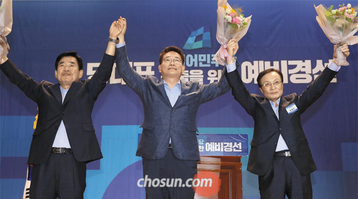 3인의 與 당대표 후보 - 26일 국회에서 열린 더불어민주당 차기 당대표 후보 예비 경선에서 컷오프를 통과한 김진표(왼쪽부터), 송영길, 이해찬 후보가 손을 맞잡고 만세를 부르고 있다. 세 후보는 다음 달 25일 전당대회에서 본선을 치른다.