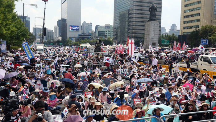 38도 폭염에도… 거리로 - 15일 오후 서울 종로구 교보생명빌딩 앞에서 열린 ‘건국 70주년 기념식 및 8·15 국가해체세력 규탄 범국민대회’에 참석한 보수단체 회원들이 집회하고 있다. 낮 최고 기온이 38도를 기록한 이날 광화문 일대와 서울역 광장 등 5곳에서 진행된 집회에는 보수단체 회원 2만7500명(집회 신고 인원)이 모였다.
