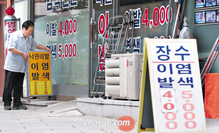 30일 오후 서울 종로구 탑골공원 인근 낙원이발관 사장 김광래씨가 인상된 이발 가격이 표시된 간판을 가게 앞에 세우고 있다. 최근 상승한 자재비와 인건비를 감당하기 어려워진 탑골공원 주변 이발소들은 20년 만에 이발비를 기존 3500원에서 4000원으로 올렸다.