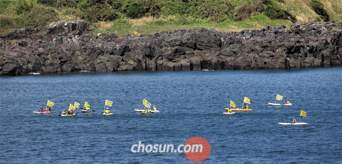 11일 대한민국 해군 국제관함식이 열린 제주 해군기지 근해에서 시민단체 회원들이 카약을 타고 관함식 반대시위를 벌이고 있다.